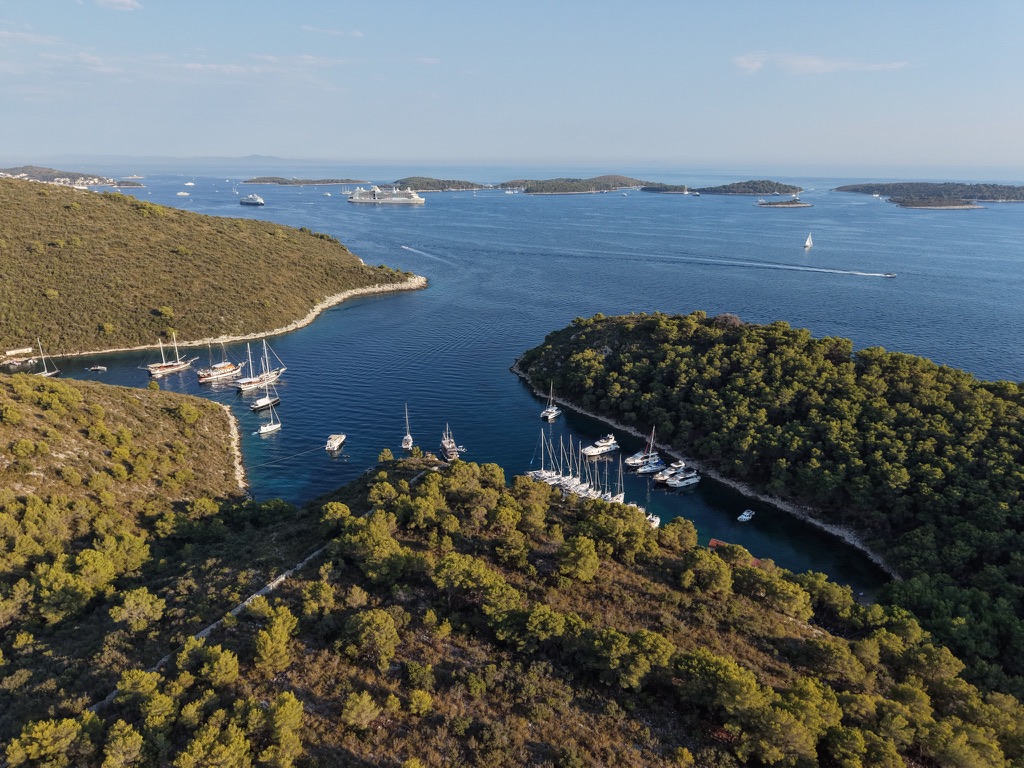 Uitzicht vanuit de lucht over groene eilanden, een baai en zeilboten